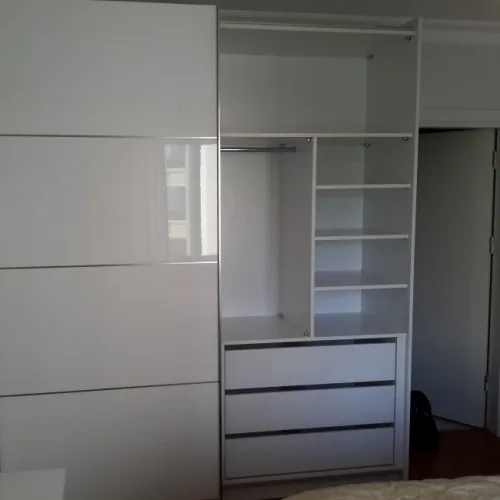 Beyaz sürgülü gardırobun çekmece ve raflı iç düzeni