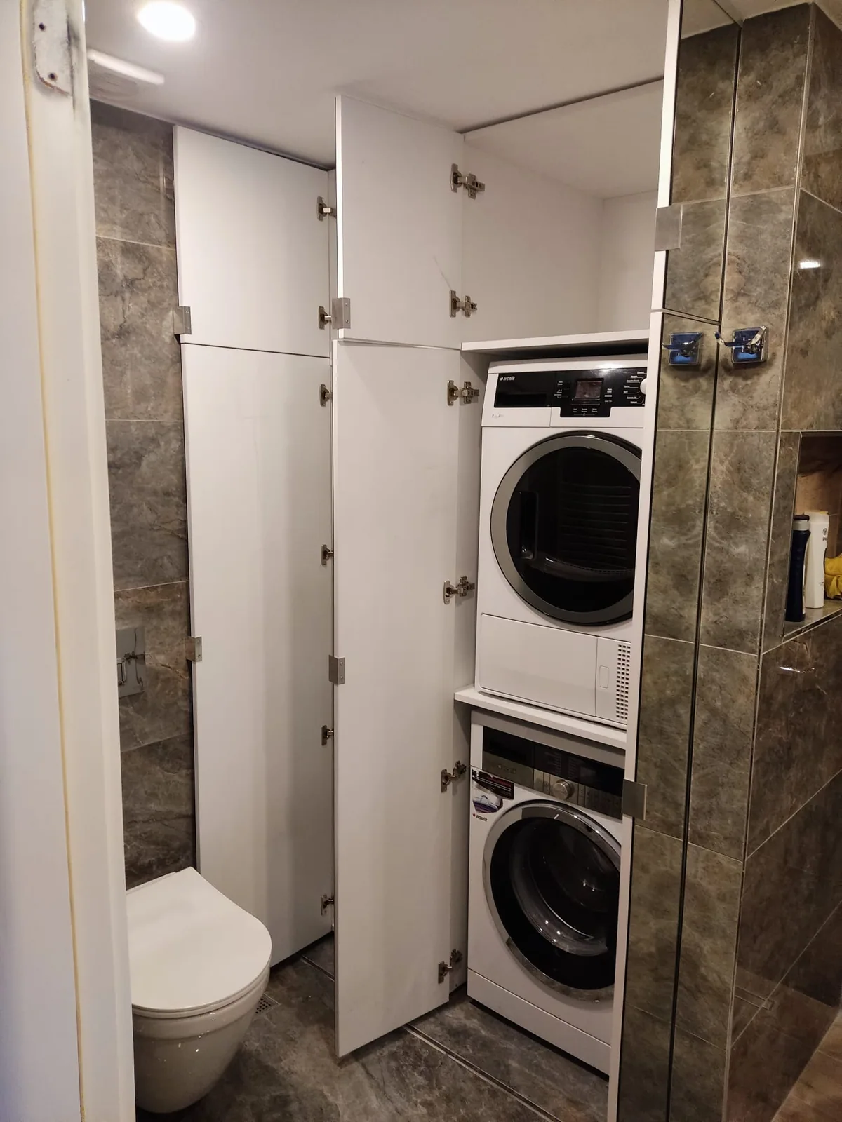 Çamaşır makinesi nişi ve üst depolamasıyla beyaz banyo dolabı